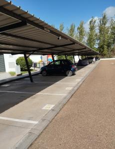 parking z samochodami zaparkowanymi pod dachem w obiekcie Casa Golf49 con parking w mieście Badajoz