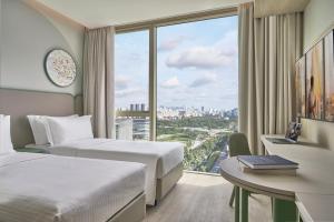 新加坡Citadines Science Park Singapore的一间有两张床、一张桌子和一扇窗户的酒店房间