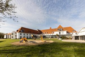 um parque infantil em frente a um grande edifício em Corsendonk Duinse Polders em Blankenberge