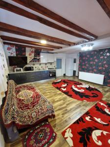 a large room with carpets on the floor and a kitchen at Casa Tru in Zărneşti