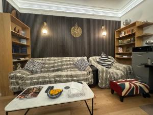 a living room with a couch and a table at The GG Spot Gledhow Gardens South Kensington Central London by Wild Boutique in London