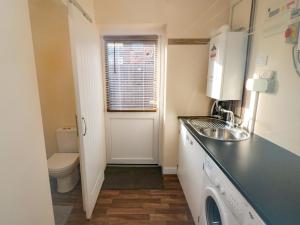 a small kitchen with a sink and a toilet at 31A The Green in Scarborough +18 photos