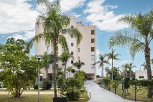 a building with palm trees in front of it at Playamarinsa in Torre del Mar