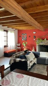 un soggiorno con divano e parete rossa di Casafamiliar a Villa San Nicolás