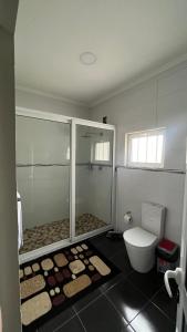 a bathroom with a glass shower and a toilet at Estadia alegre ao som do mar in Maputo +11 photos