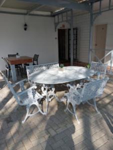 einen weißen Tisch und Stühle auf der Terrasse in der Unterkunft Victorian Lodge in Bloemfontein