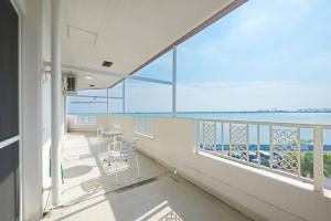a balcony with a chair and a view of the ocean at ライカムまで車で7分 オーシャンビュー付き 最大8人 駐車場2台 長期滞在にもおすすめ MK1 in Okinawa City