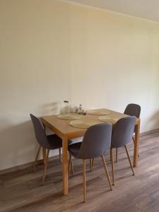 einen Holztisch mit vier Stühlen in einem Zimmer in der Unterkunft Family Apartment MiniGlück in Sankt Englmar