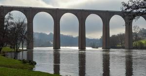 a bridge with arches over a body of water at Beau Maison in Le Vigeant