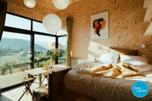 a bedroom with a bed and a table and a window at Ecolodge Acm in Rovagny