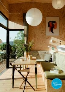 sala de estar con mesa y sofá en Ecolodge Acm Vue Lac Et Bain Nordique, en Rovagny