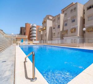 a swimming pool in front of a building at rentafive - Primera Línea - Arenales - Casa Pilar in Arenales del Sol