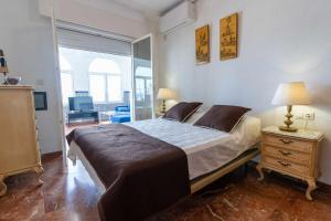 a bedroom with a large bed and a table with a lamp at rentafive - Primera Línea - Arenales - Casa Pilar in Arenales del Sol +32 photos