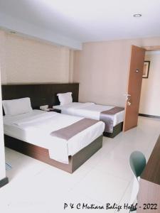 two beds in a room with two beds sidx sidx sidx sidx at Mutiara Balige Hotel in Balige