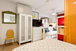 1 dormitorio con 1 cama y TV. en Casita playa, en Málaga