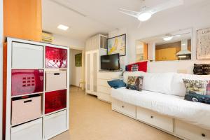 Una sala de estar con un sofá blanco y un televisor. en Casita playa, en Málaga
