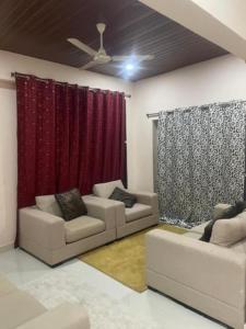 sala de estar con 2 sofás y cortina roja en Reef Hotel 1, en Hyderabad