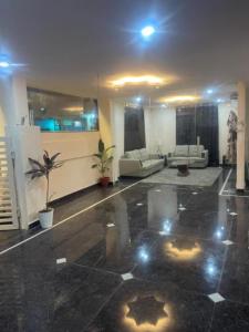 una gran sala de estar con sofás y una habitación con luces. en Reef Hotel 1, en Hyderabad