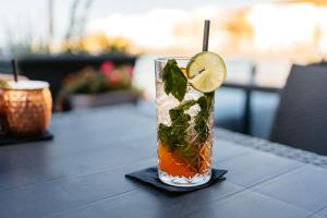 a drink on a table with a slice of lime at Southgate Hotel London in East Barnet