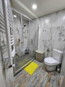 a bathroom with a toilet and a glass shower at Cozy Apartment 201A • BMIX • in Bakuriani
