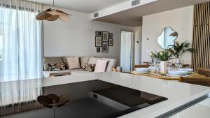 a white living room with a couch and a table at ASTER sea view apartment in Villajoyosa