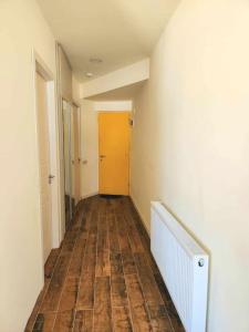 an empty hallway with a wooden floor and a yellow door at Cozy Apartment 201A • BMIX • in Bakuriani