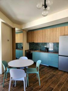 a kitchen with a table and chairs and a refrigerator at Cozy Apartment 201A • BMIX • in Bakuriani