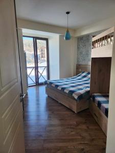 a bedroom with a bed and a door to a balcony at Cozy Apartment 201A • BMIX • in Bakuriani