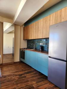 a kitchen with blue cabinets and a white refrigerator at Cozy Apartment 201A • BMIX • in Bakuriani