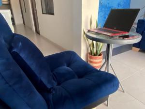 a blue couch sitting next to a table with a laptop at Hotel Brisas in Guamal