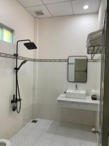 La salle de bains est pourvue d'un lavabo et d'un miroir. dans l'établissement Mango Beach Hotel & Camping, à Ấp Khánh Phước (1)