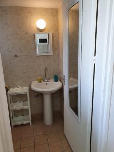 a bathroom with a white sink and a mirror at Sea Apartments in Larnaka