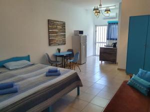 a bedroom with a bed and a kitchen with a table at Sea Apartments in Larnaka