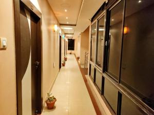 a long hallway with potted plants on the walls at HOTEL SUN CITY in Puri