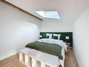 a bedroom with a bed with a green headboard at [PARENTHESE] Le Green in Saint-Jory