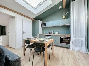 a kitchen with a table and chairs in a room at [PARENTHESE] Le Green in Saint-Jory