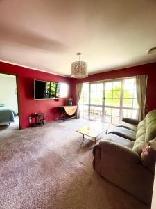 a living room with a couch and a table at Horse Shoe Manor in Paihia