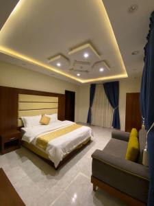 1 dormitorio con 1 cama grande y 1 sofá en برج ملاذ للشقق المخدومة بوادي بن هشبل en Bin Hashbal
