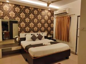 um quarto com uma cama grande e um espelho em HOTEL SUN CITY em Puri