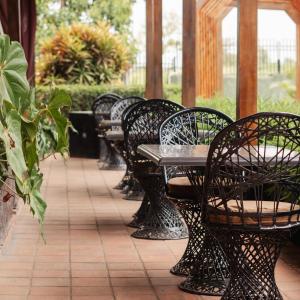 une rangée de bancs avec tables et chaises dans l'établissement Acacia Country Inn, à Mbarara