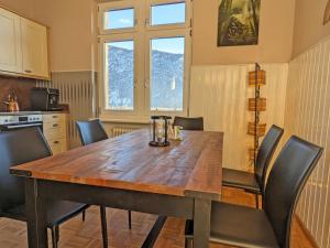 a kitchen with a wooden table with chairs around it at Villa Steinmetz in Kiefersfelden