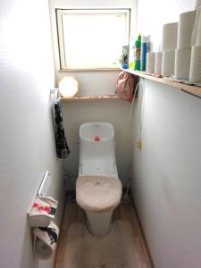 a small bathroom with a toilet with a window at 農家民泊せたな牛ハウス in Setana