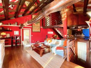 a living room with red walls and a wooden ceiling at l ' HARMATTAN in O Barqueiro