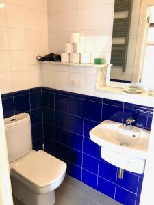 a blue and white bathroom with a toilet and a sink at l ' HARMATTAN in O Barqueiro +36 photos