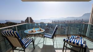 un balcón con sillas y una mesa en la parte superior de un edificio en TORRE LUGANO sea view apartment, en Benidorm