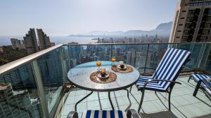 - Balcón con mesa y sillas y vistas a la ciudad en TORRE LUGANO sea view apartment, en Benidorm