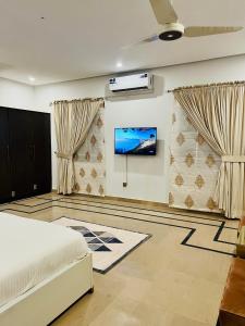 a bedroom with a bed and a tv on a wall at The Gateway islamabad in Islamabad