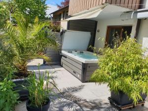 a hot tub in a backyard with plants at Seehaus Aachblick, Stilvolle Apartments und Ferienwohnungen in Uhldingen-Mühlhofen