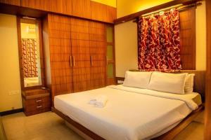 a bedroom with a bed with a red curtain at 2BHK Modern Suites in North Goa in Saligao