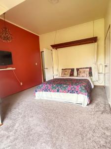 a bedroom with a large bed and a flat screen tv at Horse Shoe Manor in Paihia